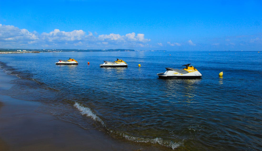 A line of rentaSkii Yamaha jet skis moored off the Gulf shore